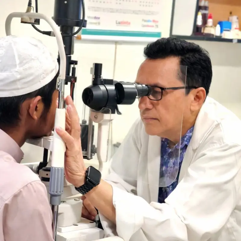 Dr. Md. Salahuddin Rahmatullah Shaheen, ophthalmologist and pediatric squint specialist, performing a clinical eye examination for a patient.